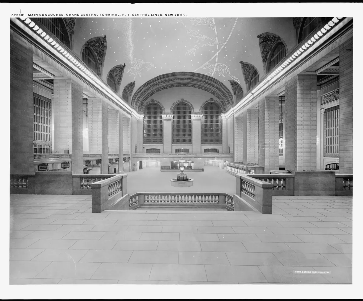 The main concourse of Grand Central Terminal, with travelers crossing the floor beneath tall arched windows.