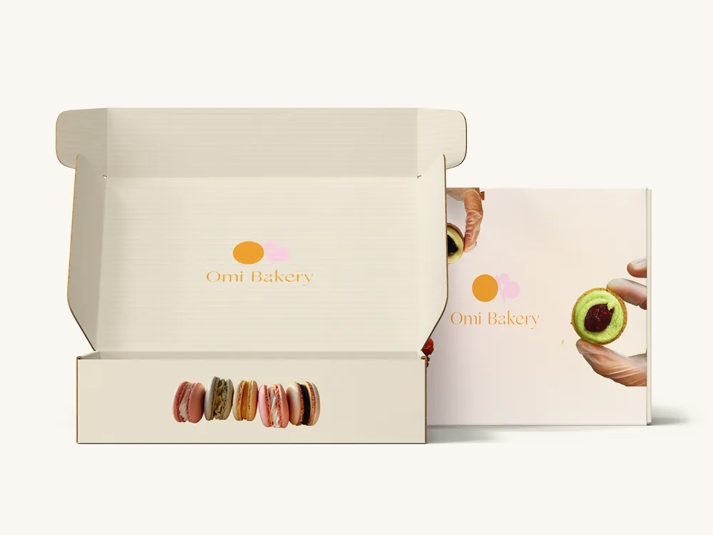 An open Omi Bakery box holding a row of macarons.