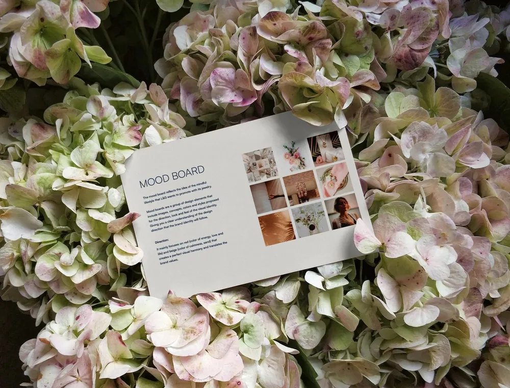 The Love & Grace mood board card resting on pink and green hydrangeas.