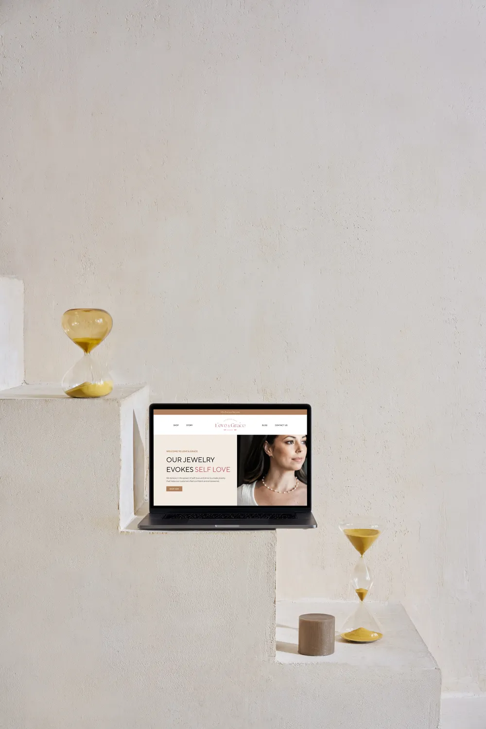 The Love & Grace website on a laptop, set on pale stone steps.