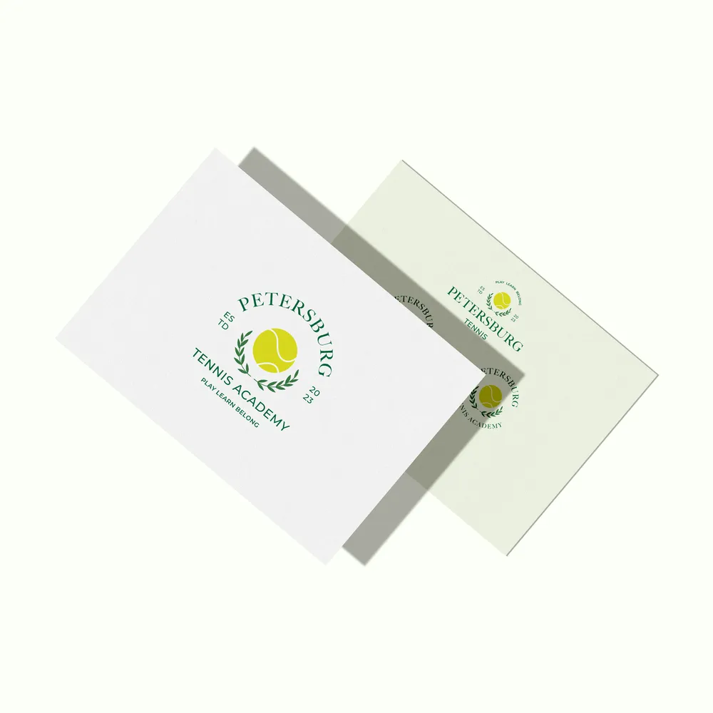 Two business cards with the academy crest, in white and pale green.