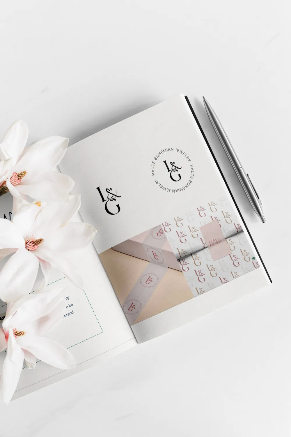 An open Love & Grace brand book with the monogram, beside white orchids.