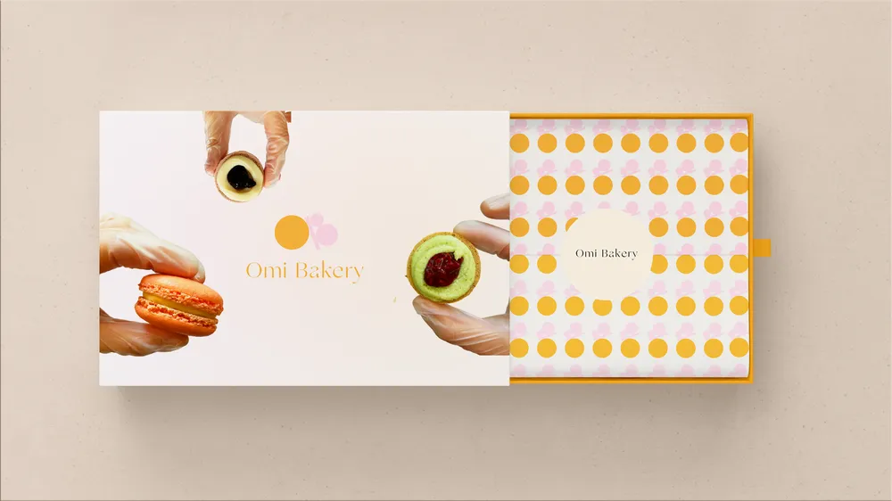 An Omi Bakery macaron box with a sleeve of orange and pink dots.