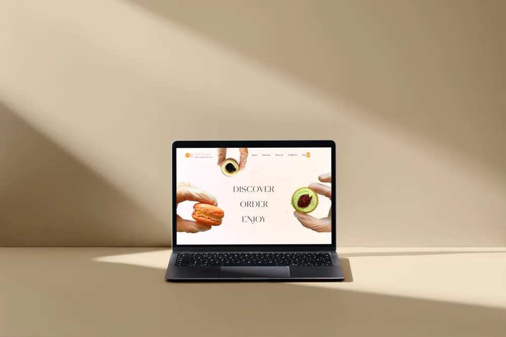 The Omi Bakery website on a laptop in warm afternoon light.